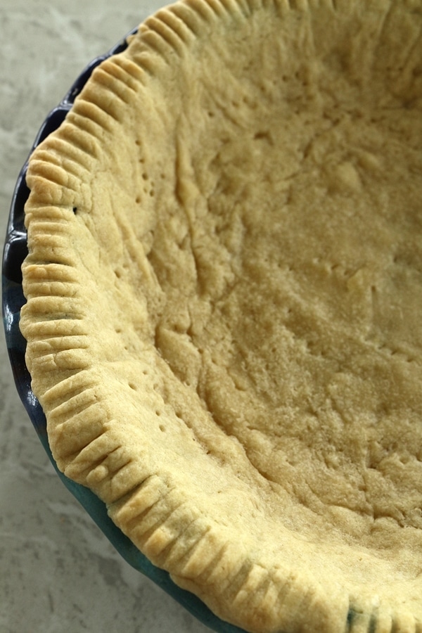 a baked pie crust in a blue pie dish