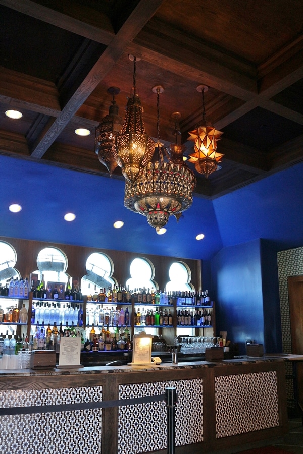 restaurant bar with bright blue walls and gold chandelier