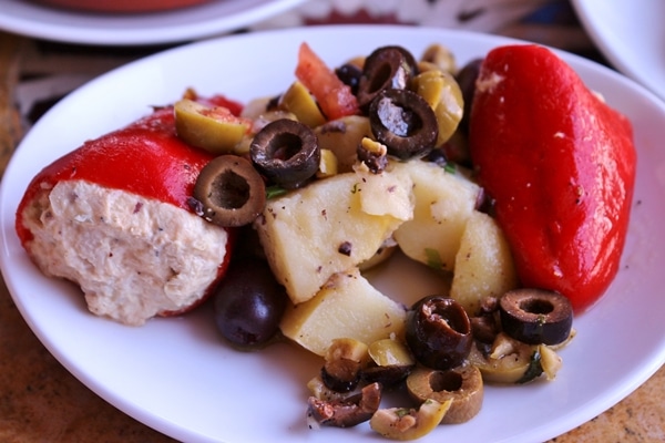 piquillo peppers and potato and olive salad on a white plate