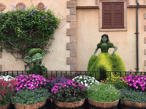 a topiary display of Snow White and Dopey