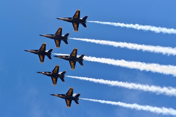 A group of fighter jets flying through a blue sky