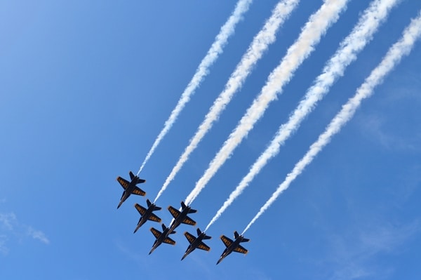 A group of fighter jets flying through a blue sky