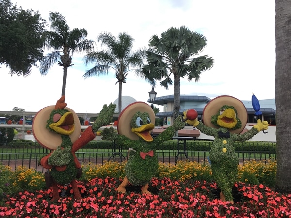 a topiary display of The Three Caballeros with palm trees behind them