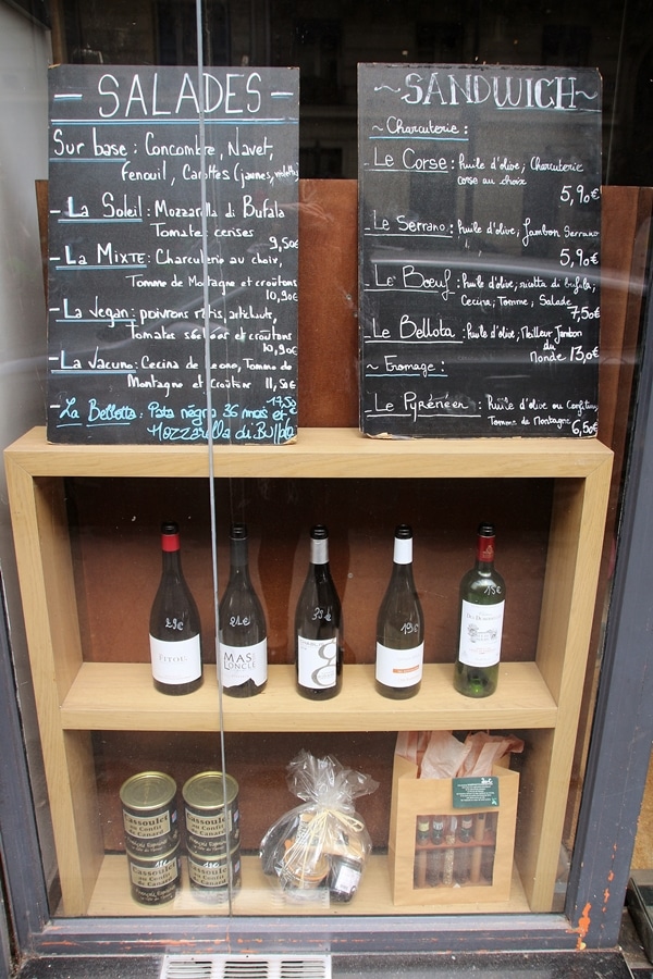 chalkboard menus and bottles of wine inside a restaurant window