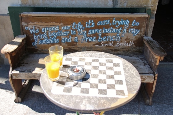 A wooden bench with a small checkerboard table