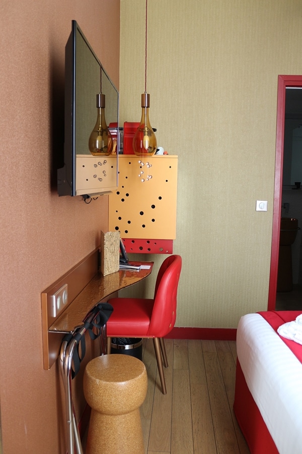 A chair sitting in front of a small desk in a hotel room