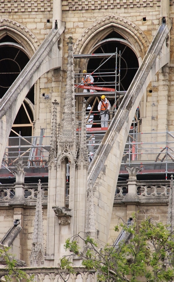 closeup of construction workers in Notre Dame