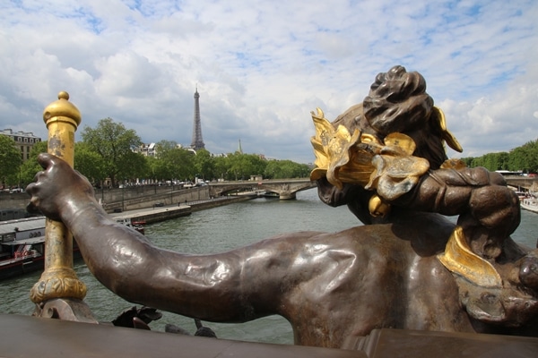 A statue of a person with the Eiffel Tower in the distance