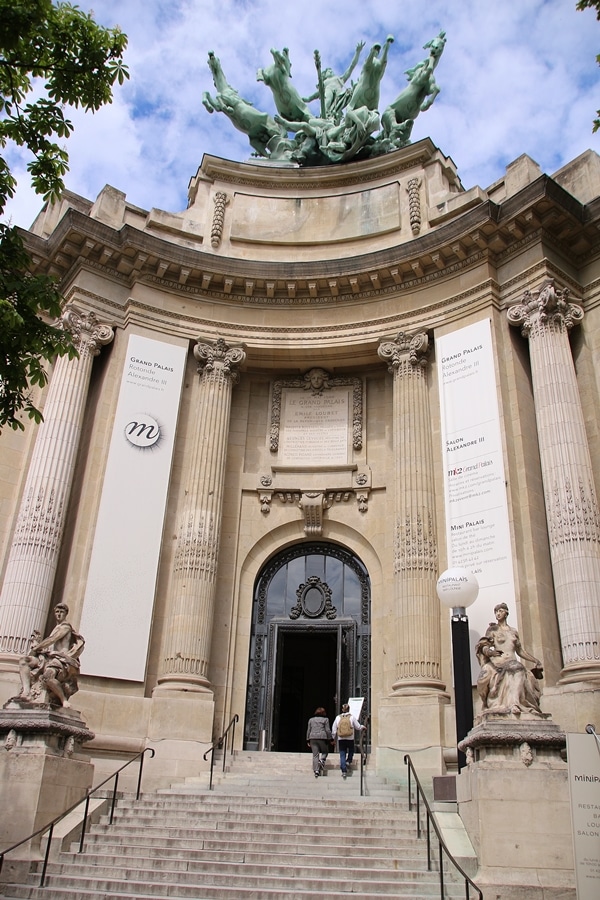 A large stone building with statues on it