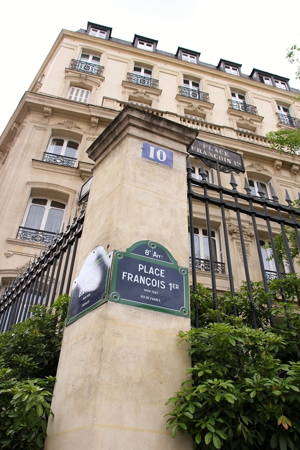 a street sign in front of a big stone building