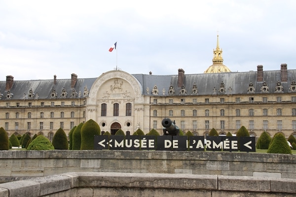 exterior of a stone building with a gold dome beyond