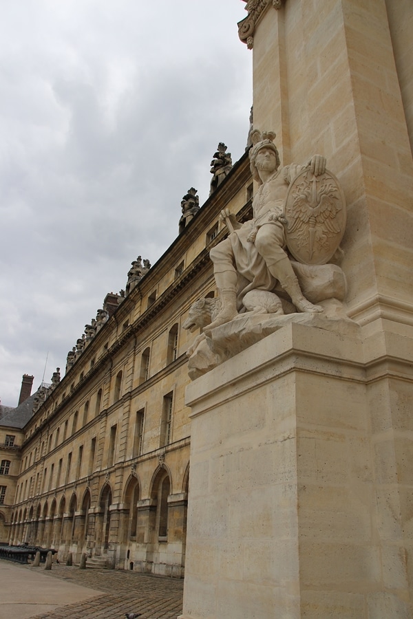 a statue on the side of a stone building