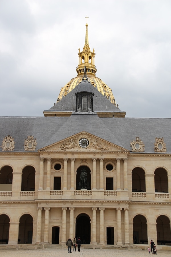 a stone building with arches, columns, and a gold dome