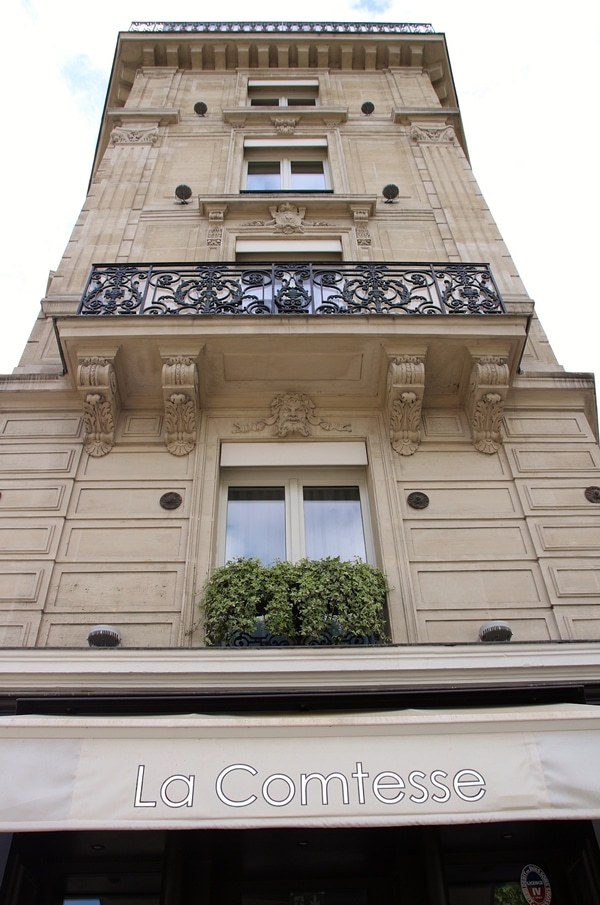 a tall building with an ornate iron grate over the balcony