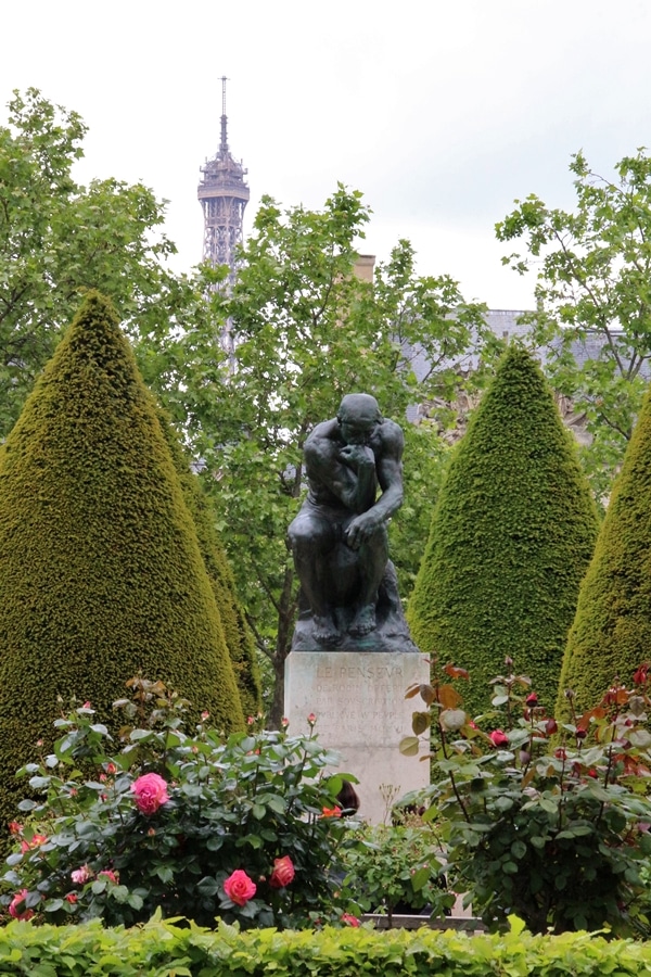 The Thinker sculpture in a flower garden