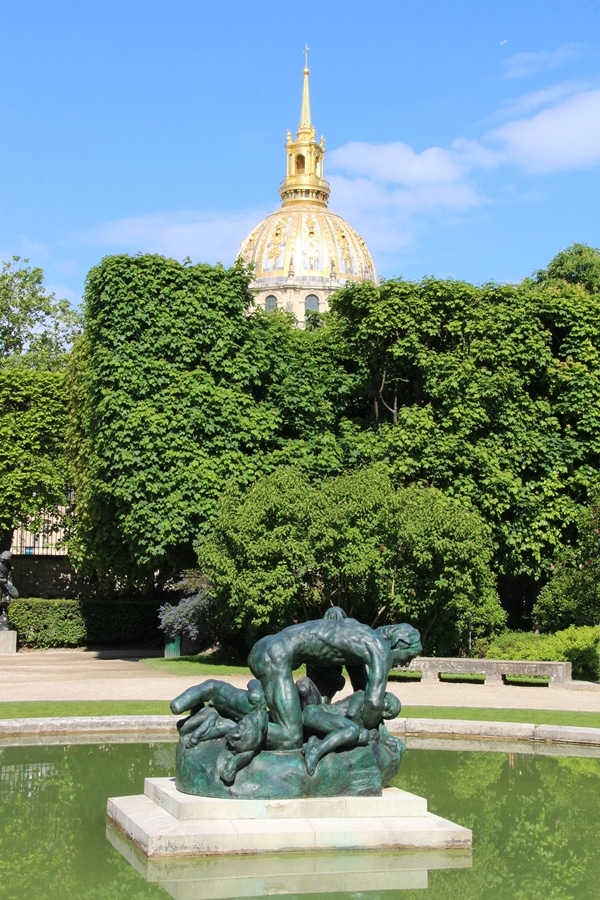 a sculpture with trees behind it