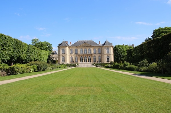 a grand building beyond a grassy field