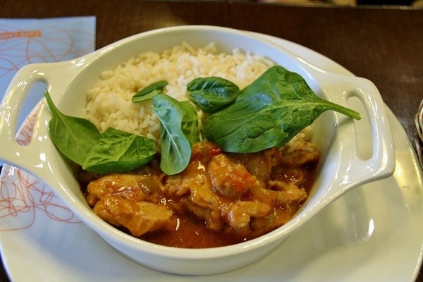 a bowl of chicken and rice with baby spinach