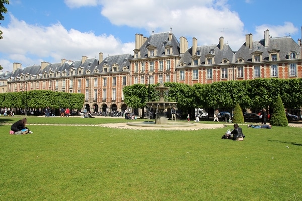 a large grassy square surrounded by pretty buildings