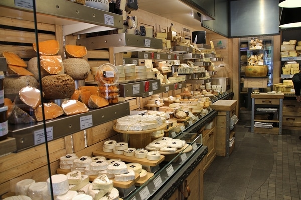 a variety of cheeses on display in a shop