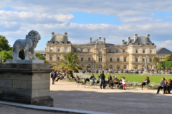 A group of people walking through Luxembourg Gardens