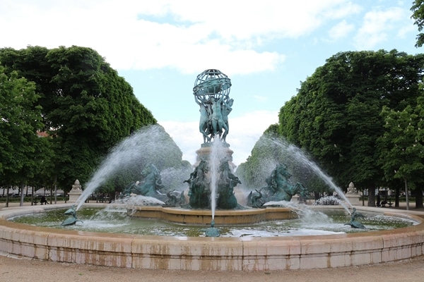 A fountain with trees on either side