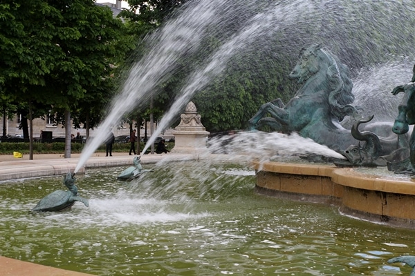 a fountain with trees in the background