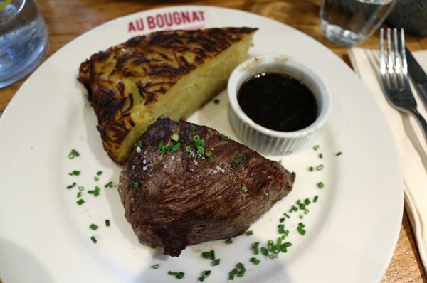 steak with a wedge of potato cake on a white plate