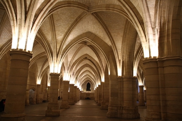 a dimly lit interior of a stone building with arches