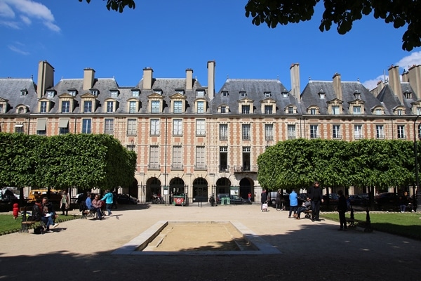 a sandbox in front of a colorful row of buildings