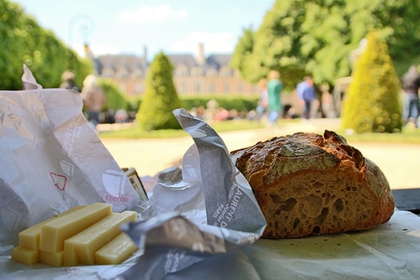 a closeup of bread and cheese with a grassy square in the distance