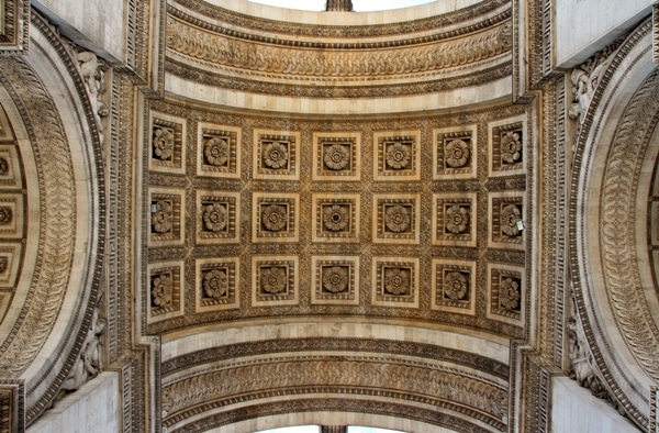 view looking up underneath the Arc de Triomphe