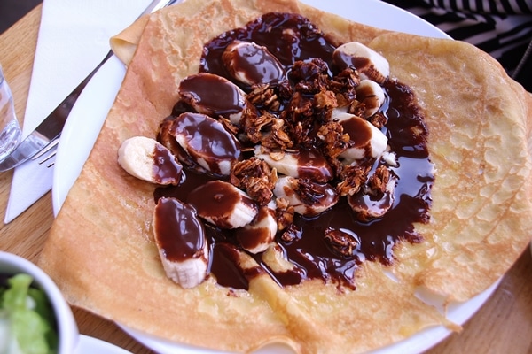 a crepe topped with bananas and chocolate sauce