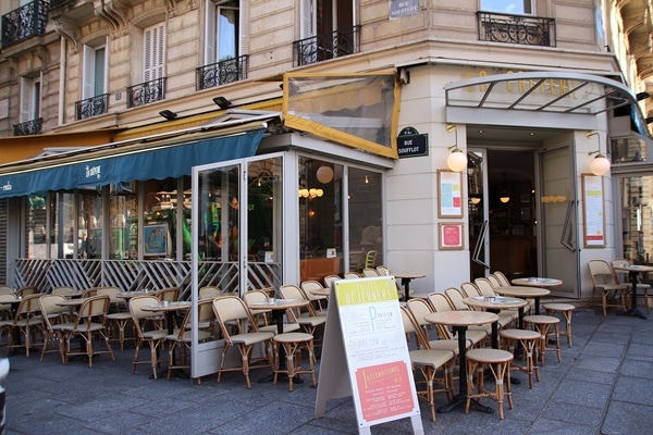 exterior of a Parisian restaurant with small tables and chairs