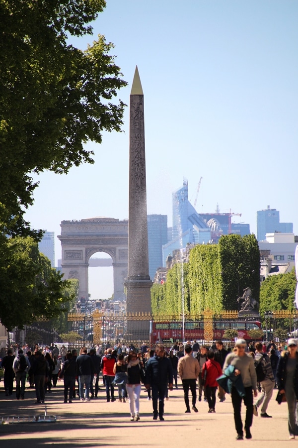 an obelisk with the Arc de Triomphe in the distance