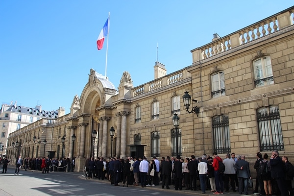 A group of people standing in front of Élysée Palace