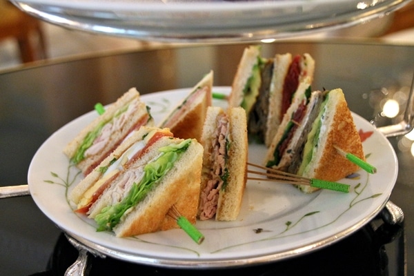 small triangular tea sandwiches on a plate