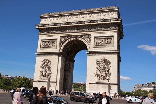 A group of people standing in front of Arc de Triomphe