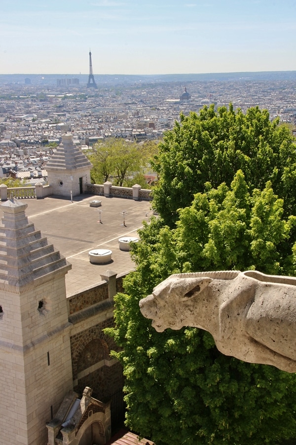 a gargoyle with Paris in the distance