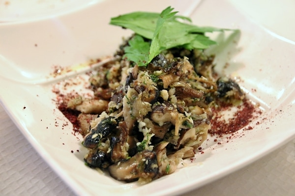 a plate of sauteed mushrooms with garlic