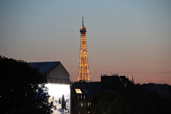 the Eiffel Tower in the distance lit up at night