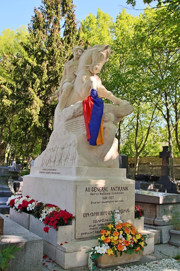 a monumental grave with an Armenian flag in a cemetery