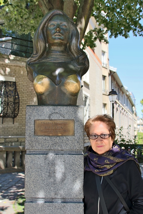 a woman posing with a statue of Dalida