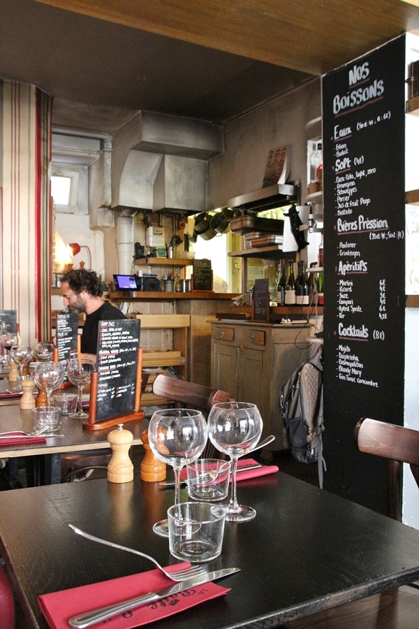 the interior of a cozy restaurant with chalkboard menus