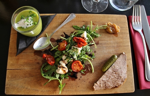 soup, salad, and pate served on a wooden board