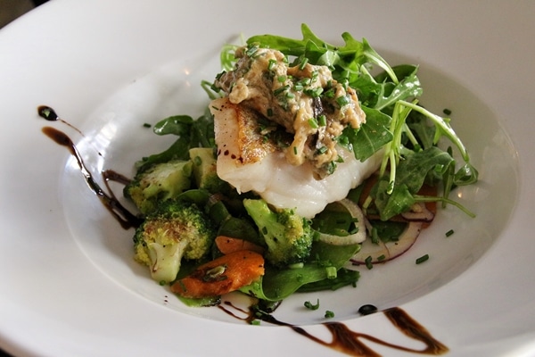 fish fillet with vegetables in a wide white bowl