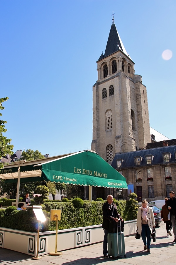 A group of people standing in front of a restaurant and a church