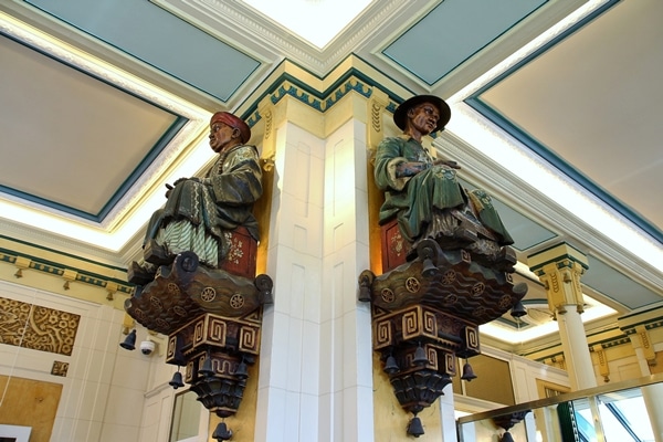 2 statues of Chinese men on either side of a column