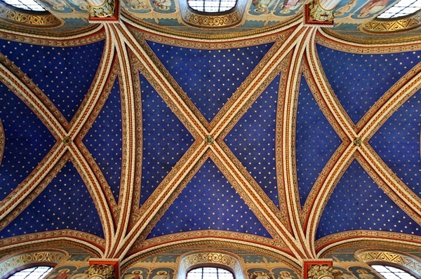 view looking up at a vaulted church ceiling painted blue with gold embellishments