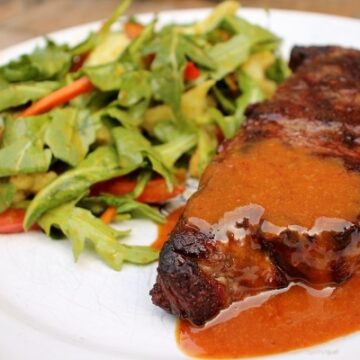 Boma mustard sauce served over steak with side of salad